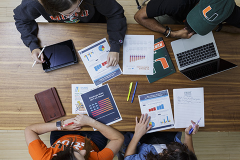 Students wearing University of Miami gear study for their Music Business class